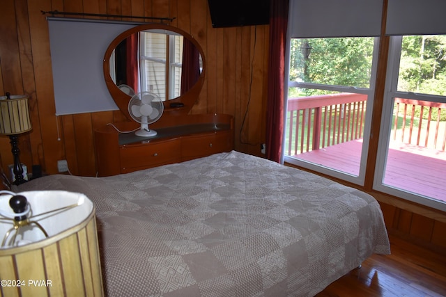 bedroom featuring access to exterior and wooden walls