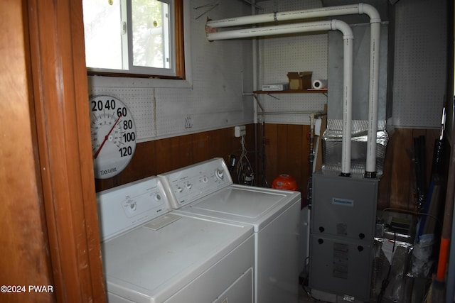 washroom with independent washer and dryer and wooden walls