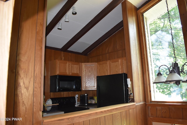 kitchen with wood walls, lofted ceiling, and black appliances