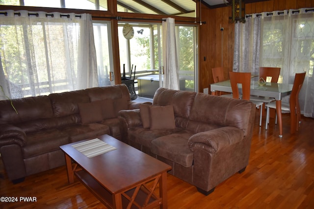 living room with wooden walls, hardwood / wood-style floors, and a healthy amount of sunlight