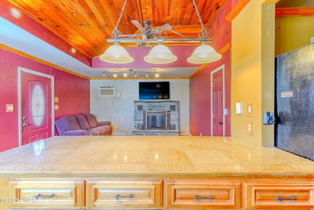 kitchen with open floor plan, an AC wall unit, a stone fireplace, track lighting, and wooden ceiling