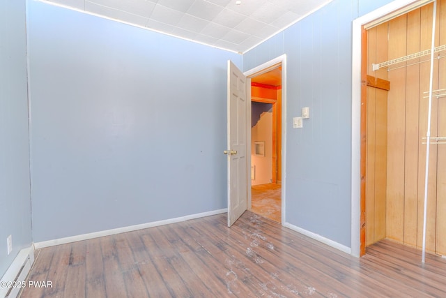 unfurnished bedroom featuring wood finished floors and baseboards