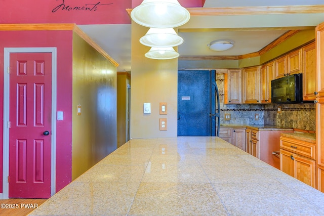 kitchen featuring brown cabinets, crown molding, tile counters, decorative backsplash, and black appliances