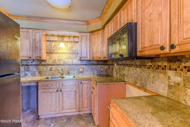 kitchen featuring crown molding, decorative backsplash, stone finish flooring, a sink, and black appliances