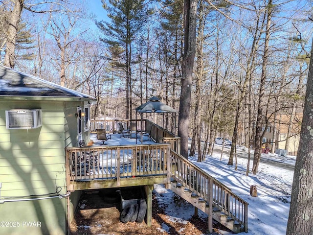 snow covered deck featuring stairs and a wall mounted AC