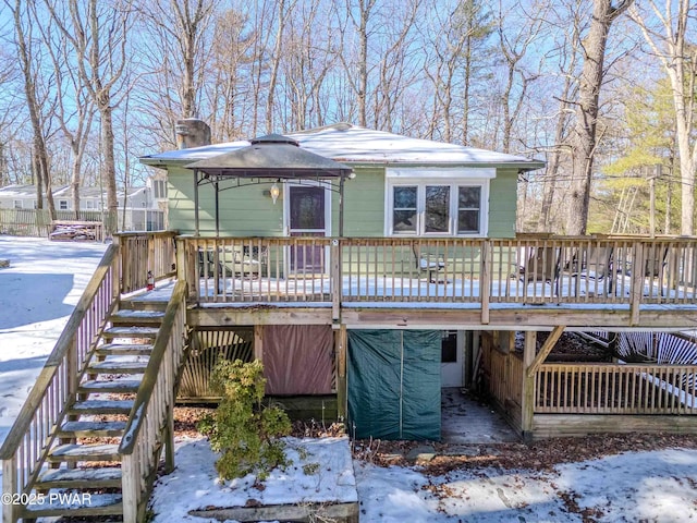 view of front of home with stairway, a chimney, and a wooden deck