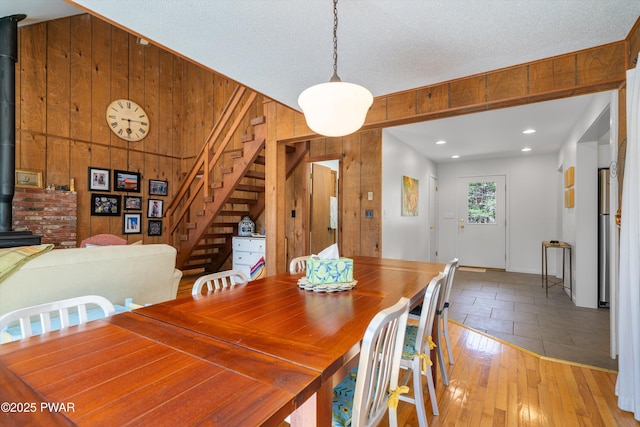 105 Tupelo Dr, Lords Valley, PA 18428 - dining area featuring a wood stove, stairway, wood walls, and light wood finished floors