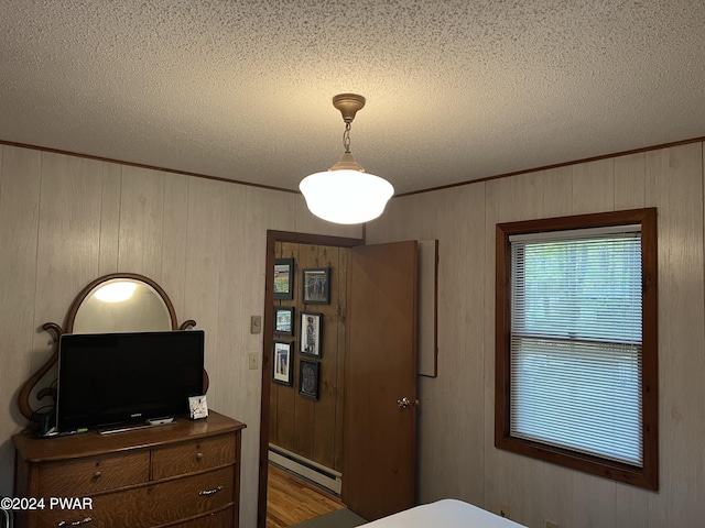 bedroom with baseboard heating and wood walls