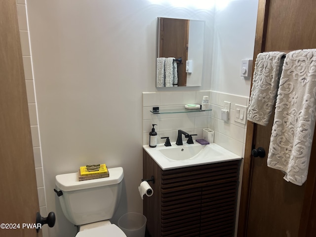 bathroom with vanity, toilet, and decorative backsplash