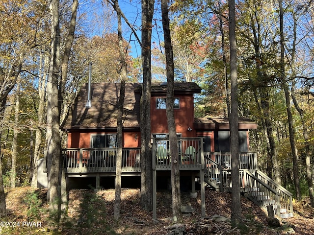 rear view of property featuring a wooden deck