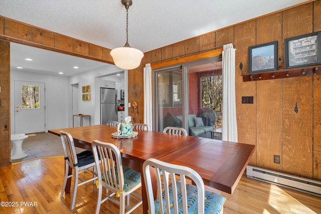 105 Tupelo Dr, Lords Valley, PA 18428 - dining space featuring a baseboard heating unit, light wood-type flooring, wooden walls, and recessed lighting