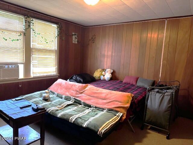 carpeted bedroom with wooden walls