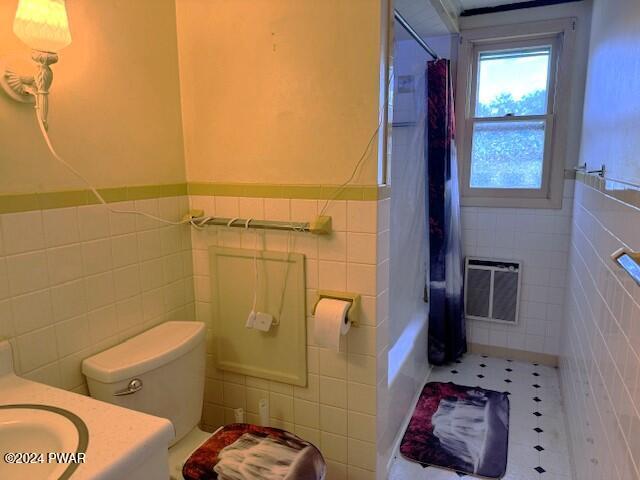 bathroom featuring tile patterned floors, toilet, tile walls, walk in shower, and heating unit