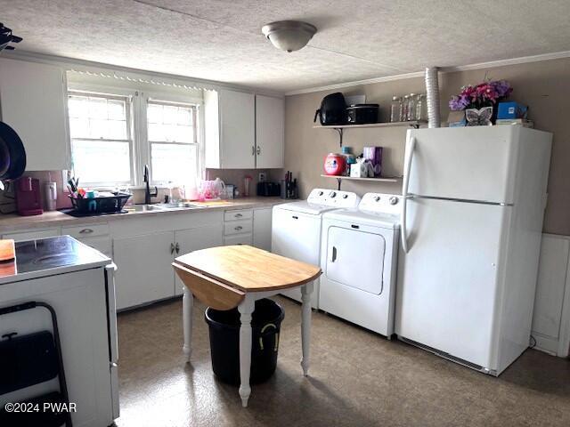 laundry area featuring independent washer and dryer, a textured ceiling, ornamental molding, and sink