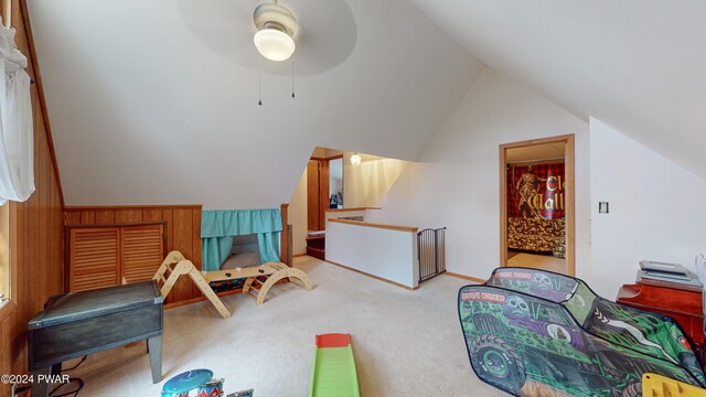 recreation room with ceiling fan, lofted ceiling, and light carpet