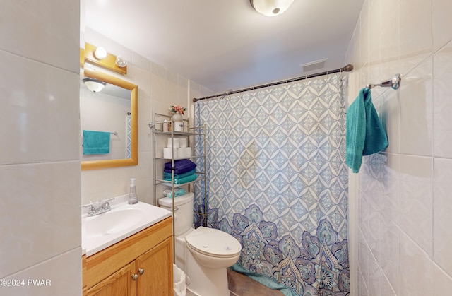 bathroom with walk in shower, vanity, tile walls, and toilet