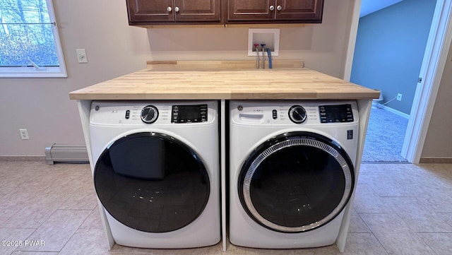 laundry room with washer and dryer, light tile patterned floors, baseboard heating, and cabinets