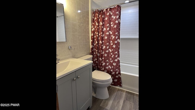 full bathroom featuring shower / bath combo, toilet, vanity, tile walls, and hardwood / wood-style flooring