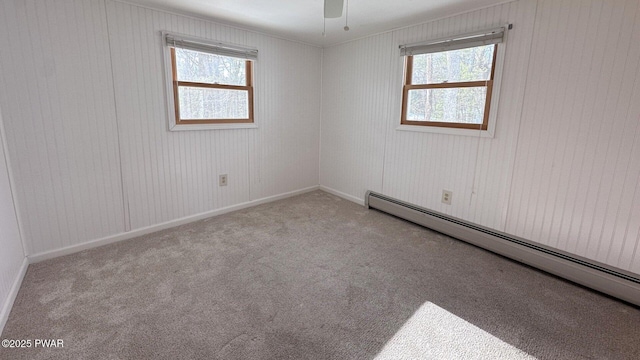 carpeted empty room with baseboard heating and ceiling fan