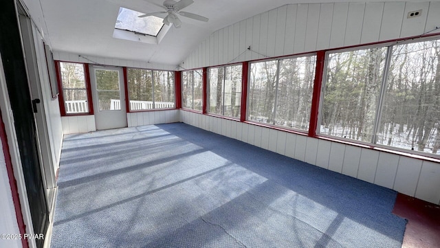 unfurnished sunroom featuring lofted ceiling with skylight and ceiling fan