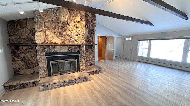 unfurnished living room featuring rail lighting, a stone fireplace, lofted ceiling with beams, a baseboard heating unit, and wood-type flooring