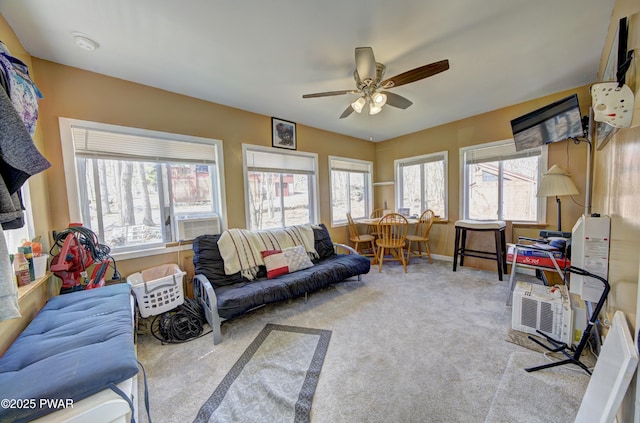 living area featuring baseboards, carpet, and ceiling fan