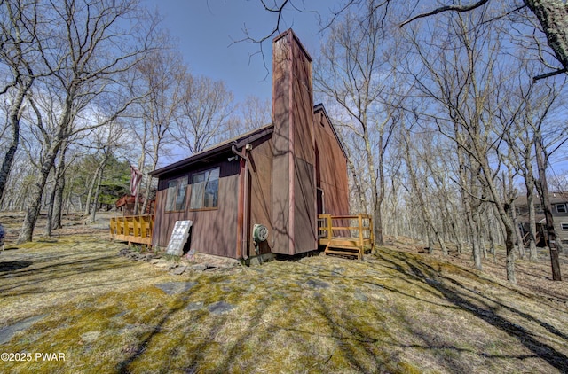 view of home's exterior with a wooden deck and a chimney