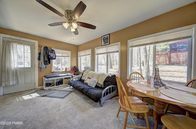carpeted living area with a ceiling fan and baseboards