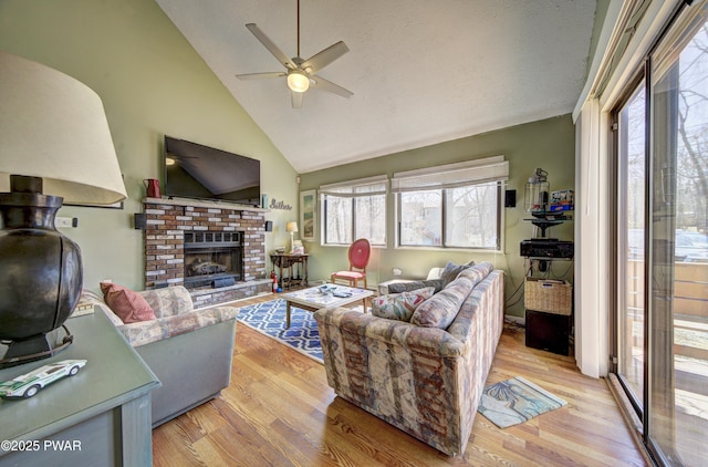 living room with a fireplace, wood finished floors, a healthy amount of sunlight, and ceiling fan
