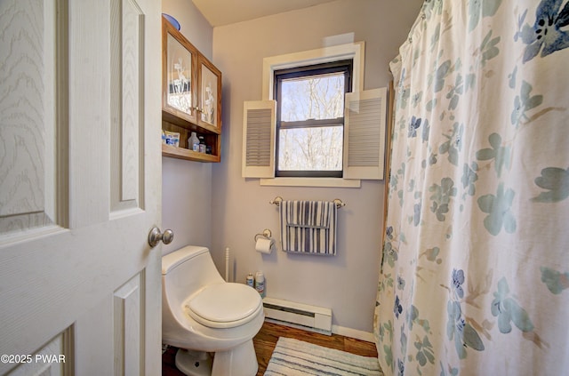 full bathroom featuring curtained shower, wood finished floors, toilet, baseboards, and a baseboard radiator