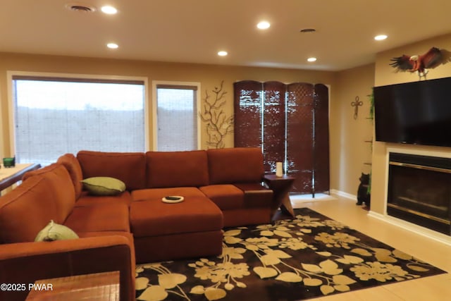 living room with visible vents, a glass covered fireplace, and recessed lighting