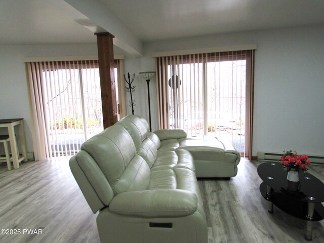 169 N Lake Dr, Dingmans Ferry, PA 18328 - living room with ornate columns, a baseboard heating unit, and wood finished floors