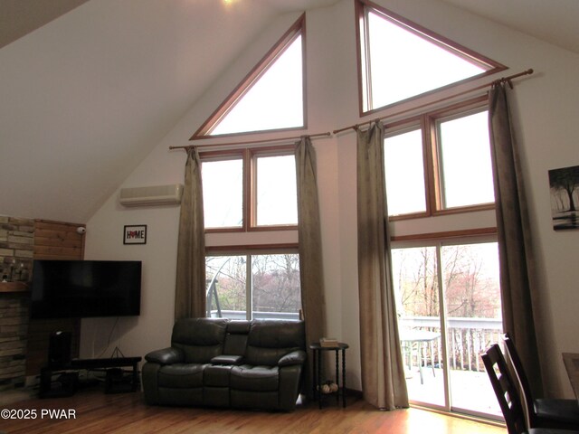 169 N Lake Dr, Dingmans Ferry, PA 18328 - living area with an AC wall unit, high vaulted ceiling, and wood finished floors