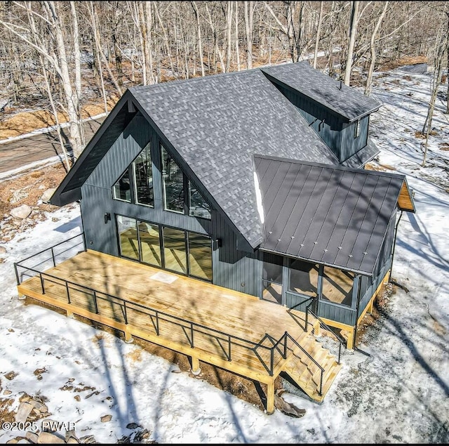 rear view of property featuring a shingled roof