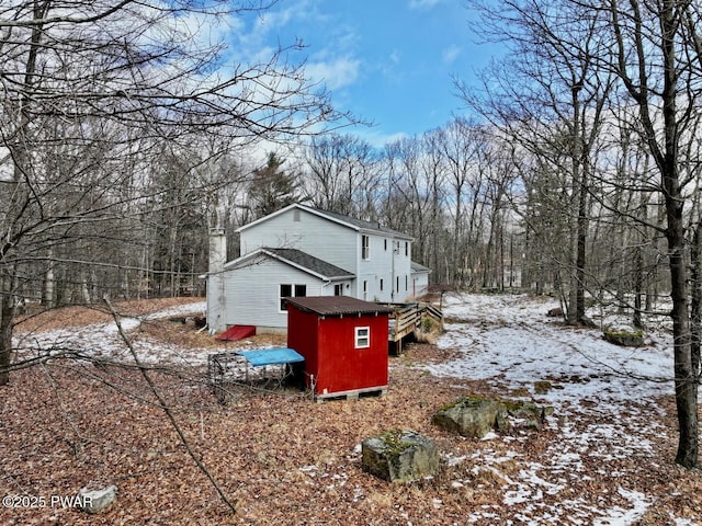 view of snow covered exterior with a storage unit