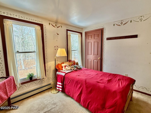 bedroom featuring multiple windows, carpet floors, and a baseboard heating unit