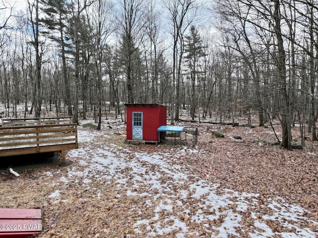 snowy yard featuring a storage unit