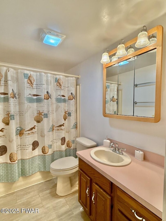 bathroom with vanity, curtained shower, and toilet