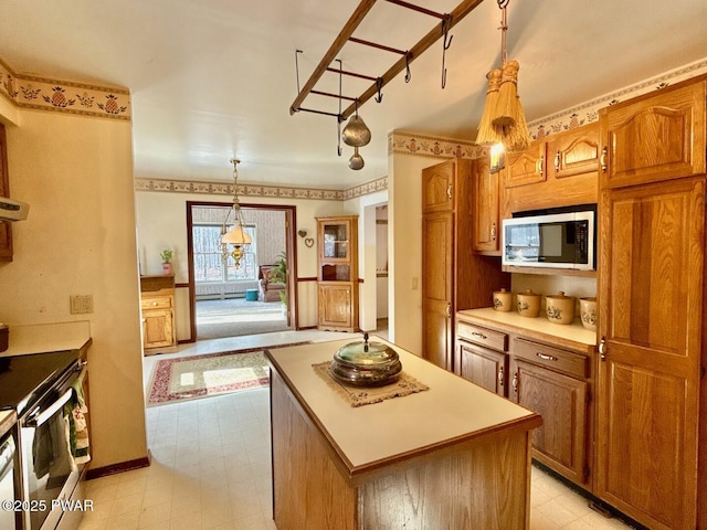 kitchen with hanging light fixtures, a kitchen island, and appliances with stainless steel finishes