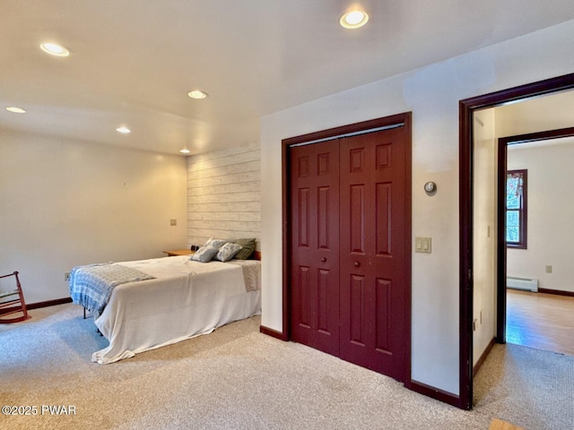 carpeted bedroom featuring a closet and a baseboard heating unit