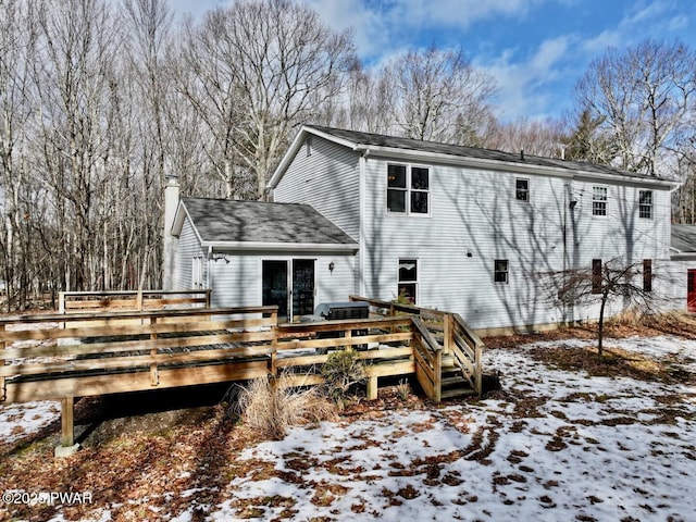 snow covered property with a wooden deck