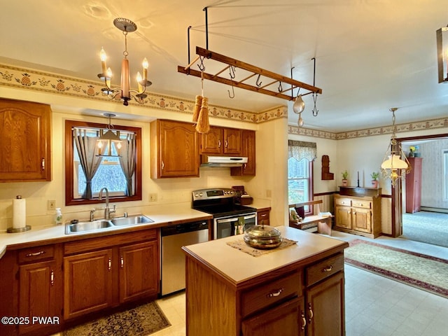 kitchen with stainless steel appliances, decorative light fixtures, sink, and a wealth of natural light