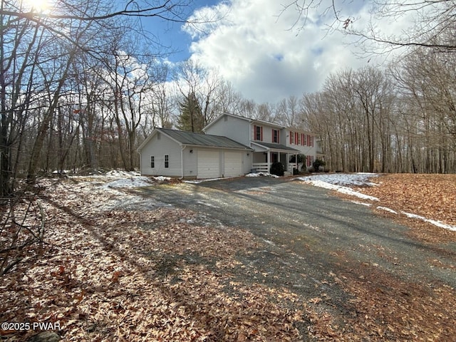 view of side of property featuring a garage and covered porch