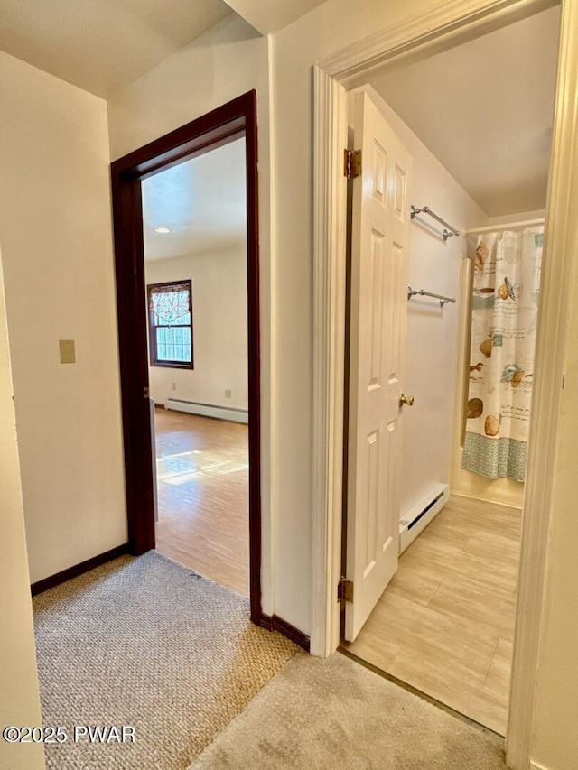 hall featuring a baseboard radiator and light carpet