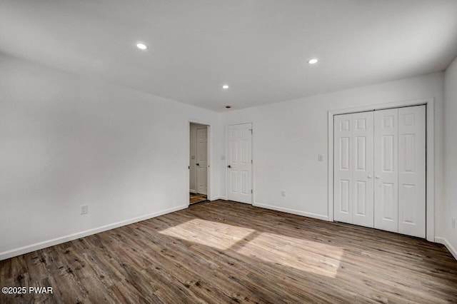 unfurnished bedroom featuring dark wood-type flooring and a closet