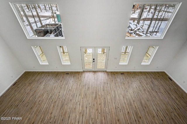 unfurnished living room with wood-type flooring and french doors