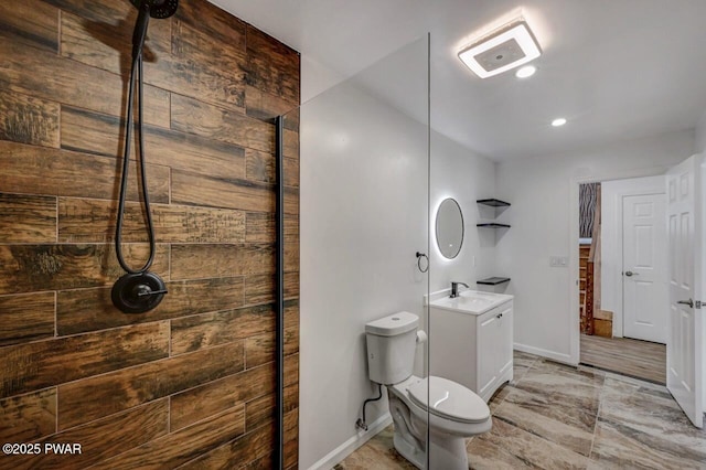 bathroom featuring vanity, tiled shower, and toilet