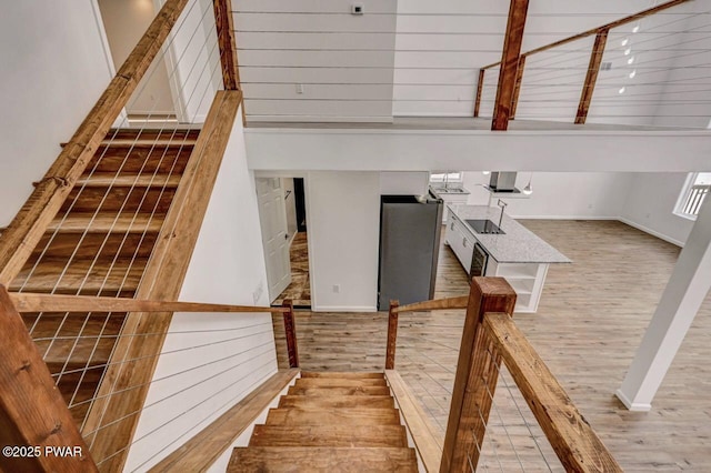 stairs featuring a towering ceiling and hardwood / wood-style flooring