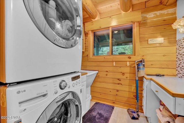 210 Fawn Lake Dr, Hawley, PA 18428 - washroom with stacked washing machine and dryer, wooden walls, and wood finished floors