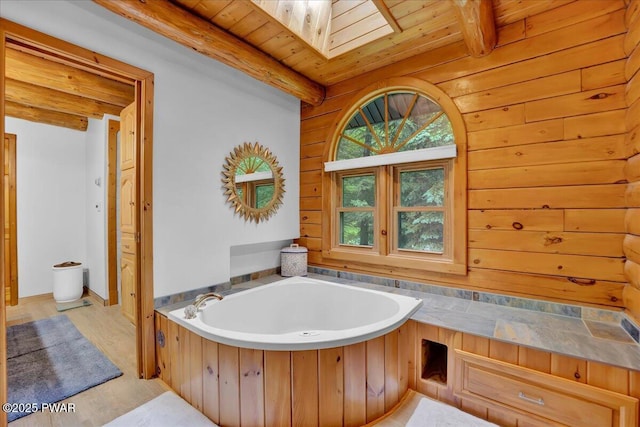 210 Fawn Lake Dr, Hawley, PA 18428 - full bathroom with a bath, a wooden ceiling with exposed beams, a skylight, and wood finished floors